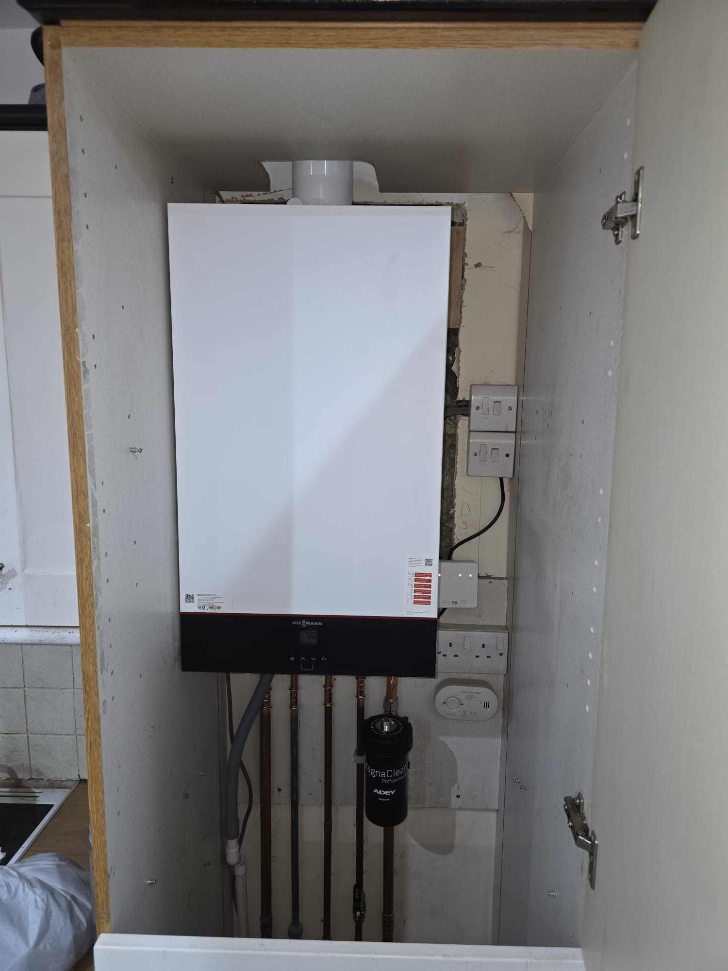 Viessmann combi boiler installation in kitchen cupboard with MagnaClean filter, Surrey