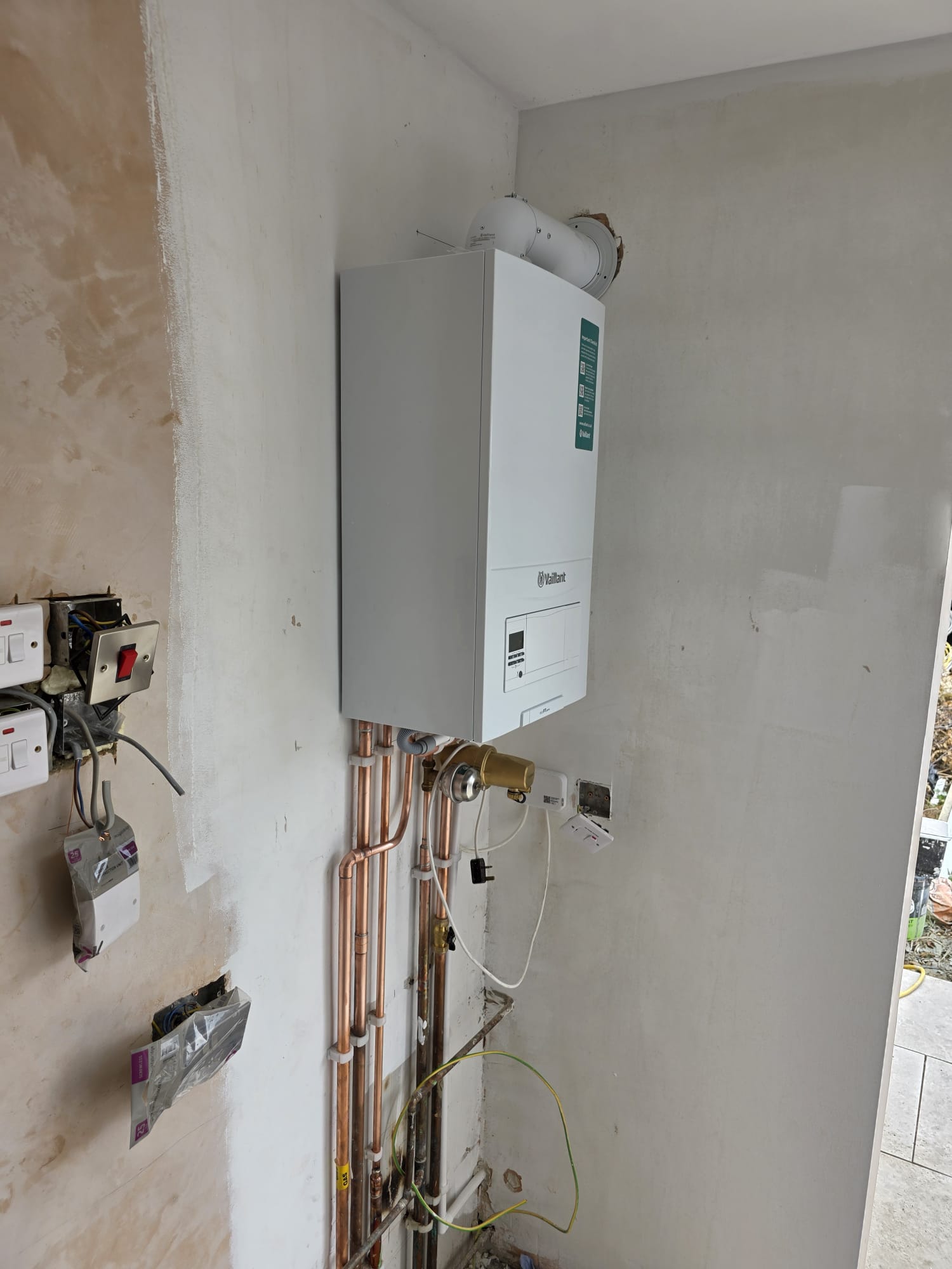 Vaillant ecoTEC combi boiler installed on freshly plastered wall, Surrey