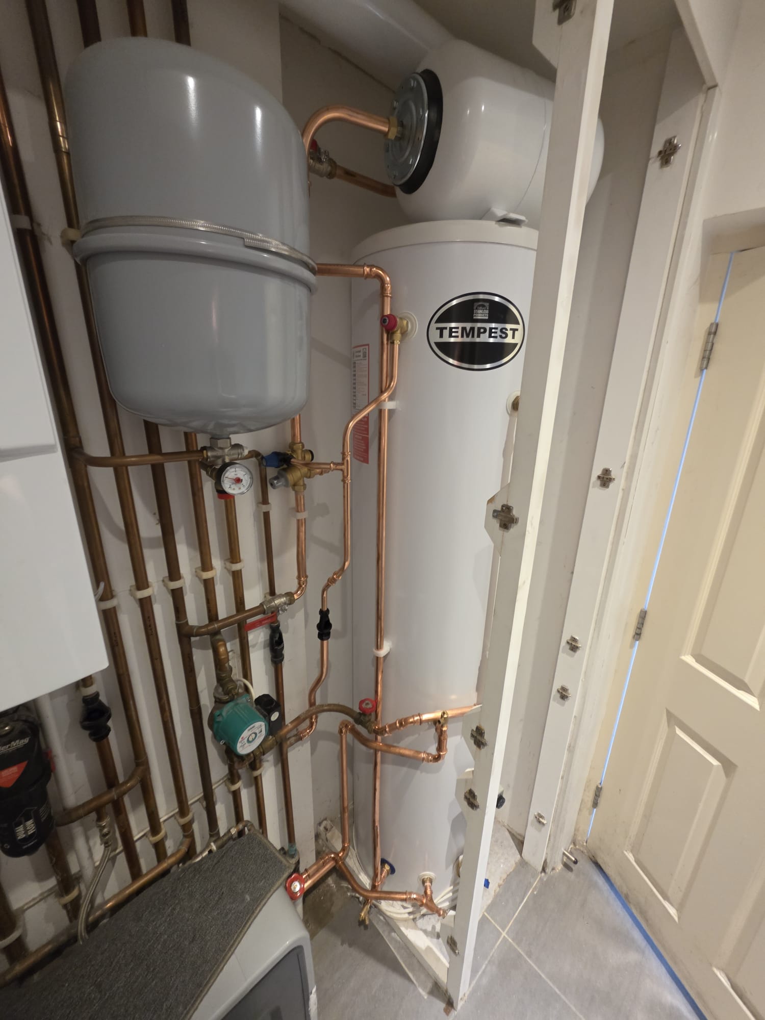 Tempest unvented hot water cylinder in airing cupboard with twin expansion vessels and copper pipework, Surrey