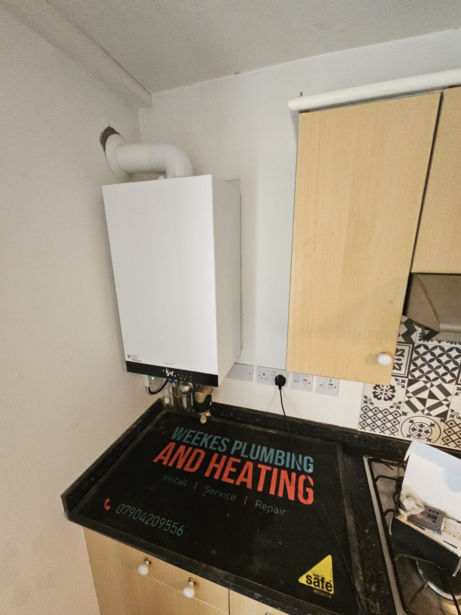 Viessmann combi boiler installation in kitchen with Weekes Plumbing branded mat